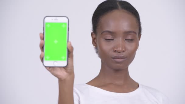 Visage de heureuse jeune belle femme africaine montrant téléphone — Video