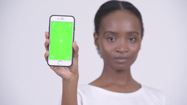 Visage de heureuse jeune belle femme africaine montrant téléphone — Video