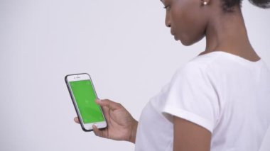 Mutlu genç güzel Afrikalı kadının telefonuyla arkadan görünüş