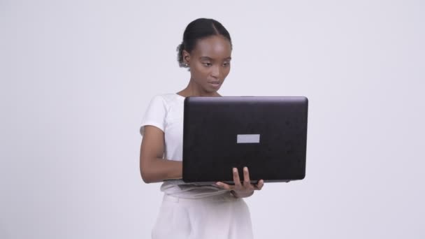 快乐年轻美丽的非洲妇女思考, 而使用笔记本电脑 — 图库视频影像
