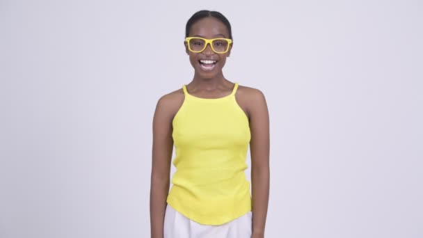 Feliz joven hermosa mujer africana sonriendo con gafas amarillas — Vídeo de stock