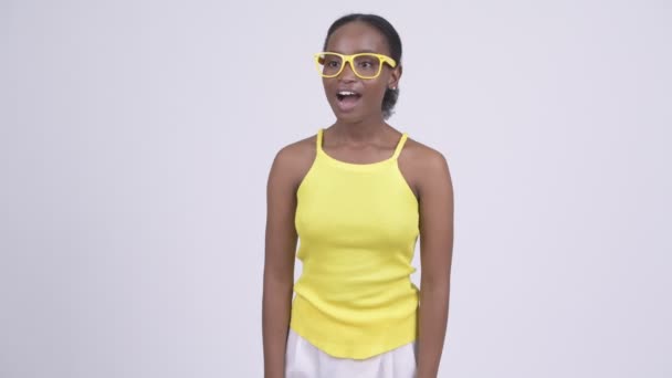 Gelukkig jonge Afrikaanse vrouw op zoek verrast en zwaaiende hand — Stockvideo