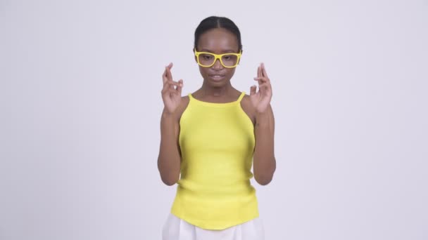 Jovem bela mulher africana com óculos amarelos desejando — Vídeo de Stock