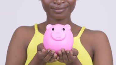 Mutlu genç Afrikalı Bayan Piggy banka tutarken gülümseyen