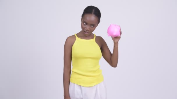 Ung stressad afrikansk kvinna skakar tom spargris — Stockvideo