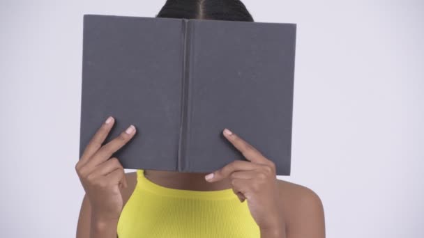 Šťastná Mladá krásná Afričanka schovává za knihu — Stock video