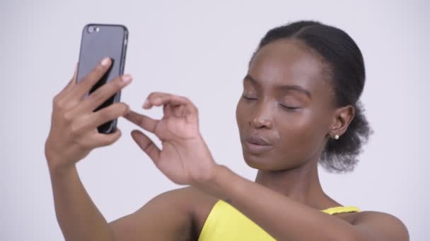 Visage de jeune belle femme africaine utilisant le téléphone et l'air choqué — Video