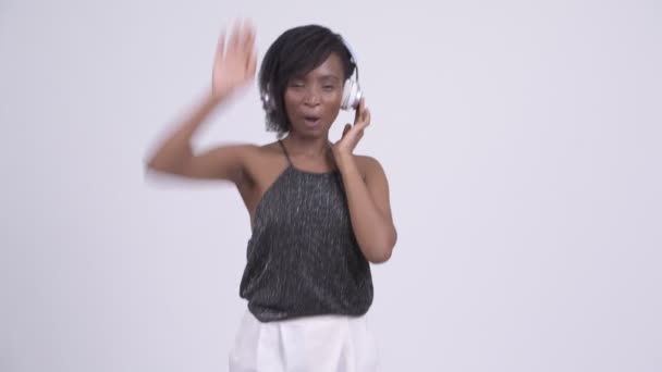 Счастливая молодая красивая африканская женщина танцует и слушает музыку — стоковое видео