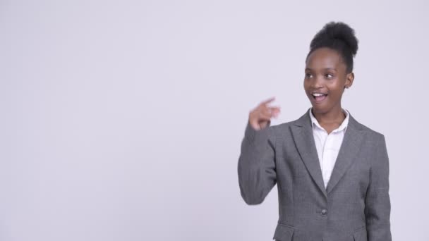 Jovem mulher de negócios africana feliz pensando e apontando para cima — Vídeo de Stock