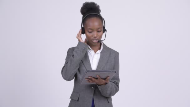 Joven mujer de negocios africana estresada como representante del centro de llamadas utilizando tableta digital — Vídeos de Stock