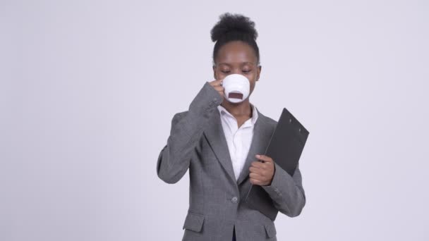 Young beautiful African businesswoman having coffee while holding clipboard — Stock Video