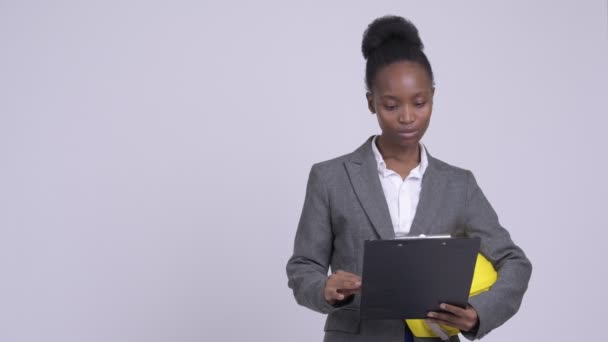 Tineri african femeie de afaceri cu hardhat obtinerea furios în timp ce citesc pe clipboard — Videoclip de stoc