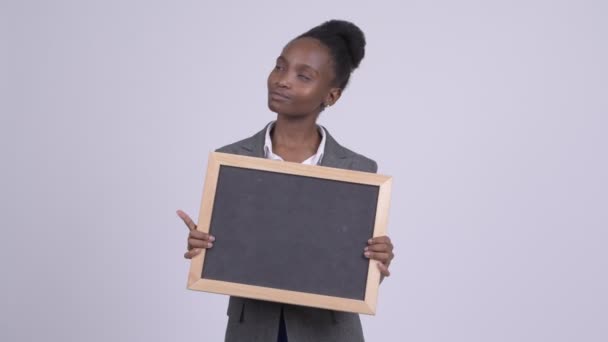 Νέοι ευτυχισμένη αφρικανική επιχειρηματίας νομίζοντας κρατώντας μαυροπίνακα — Αρχείο Βίντεο