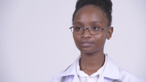 Πρόσωπο του νεαρή όμορφη αφρικανική γυναίκα γιατρός σκέφτεται — Αρχείο Βίντεο