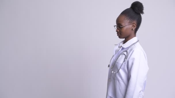 Perfil de la joven mujer africana feliz médico con los brazos cruzados — Vídeos de Stock