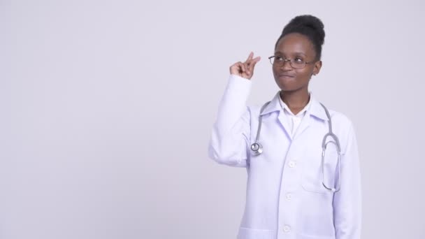 Αφρικανική ευτυχισμένη γυναίκα γιατρός σκέφτεται ενώ δείχνει προς τα επάνω — Αρχείο Βίντεο