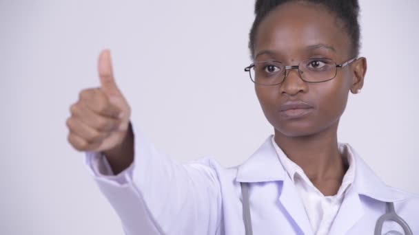 Лицо молодой счастливой африканской женщины-врача, показывающей большие пальцы — стоковое видео