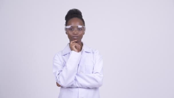 Joven mujer africana feliz médico con gafas protectoras pensando — Vídeo de stock