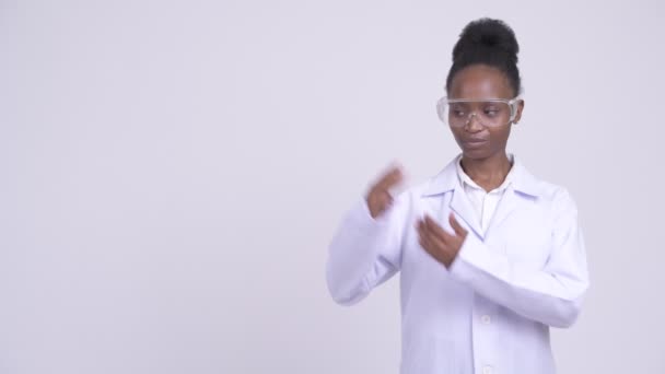 Šťastný se mladá Afričanka doktor s ochrannými brýlemi něco dávat — Stock video