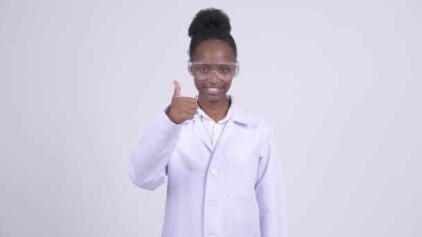Jeune femme africaine heureuse médecin avec des lunettes de protection donnant pouces vers le haut — Video