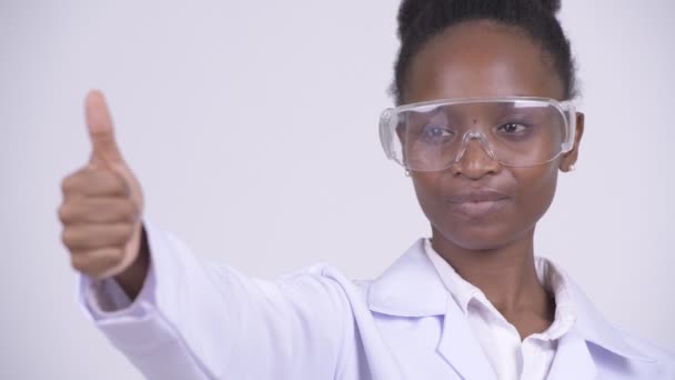 Visage de jeune femme africaine heureuse médecin avec des lunettes de protection donnant pouces vers le haut — Video