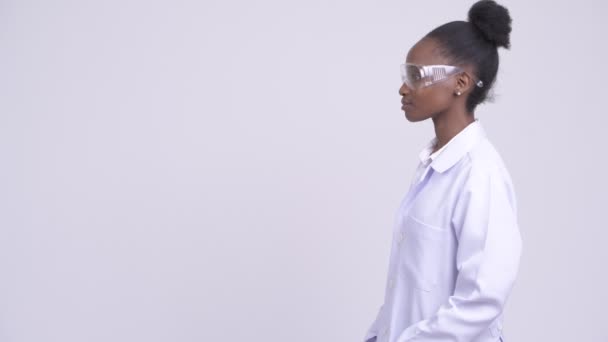 Vue du profil de jeune femme africaine médecin avec des lunettes de protection souriant — Video