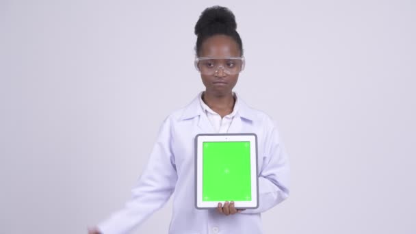 Молодая грустная африканская женщина-ученый показывает цифровые планшеты и делает большие пальцы вниз — стоковое видео