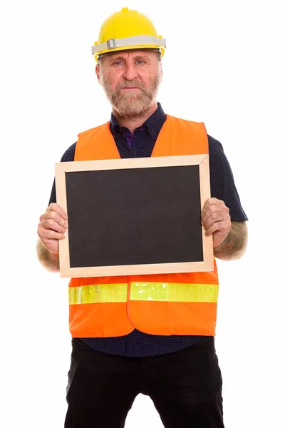 Mature bearded man construction worker holding empty blackboard — Stock Photo, Image