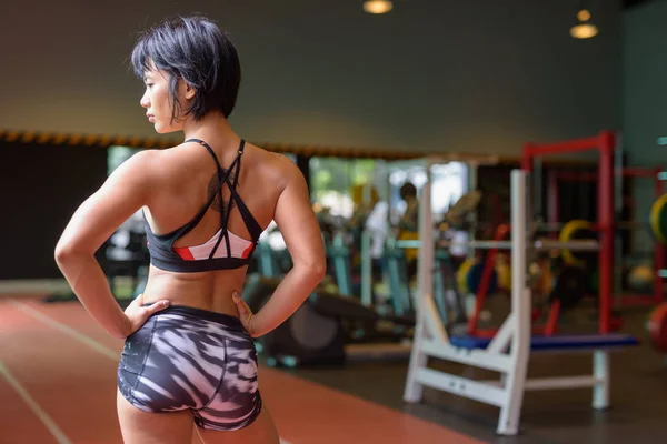 Widok z tyłu młode piękne kobiety Azjatki myślenia na siłowni — Zdjęcie stockowe