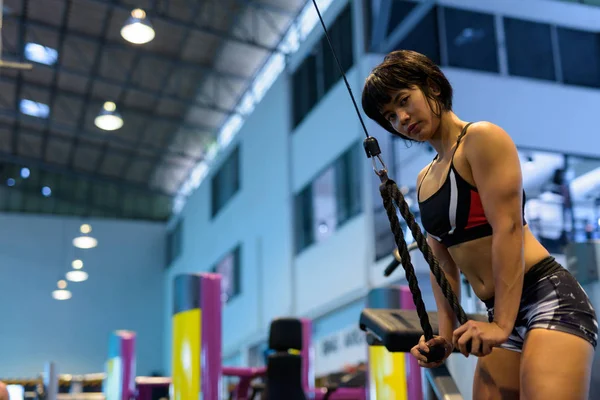 Młoda kobieta na siłowni robi ze stosem tricep z liny — Zdjęcie stockowe