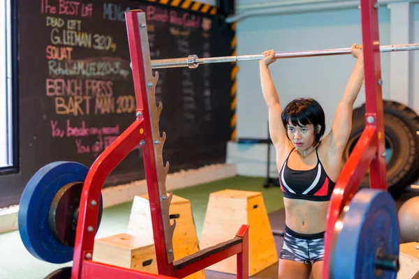 Azjatyckie kobiety, poćwiczyć na siłowni i robi prasą napowietrznych — Zdjęcie stockowe