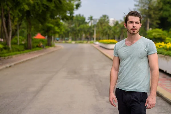 Portret van een jonge knappe man ontspannen in het park — Stockfoto