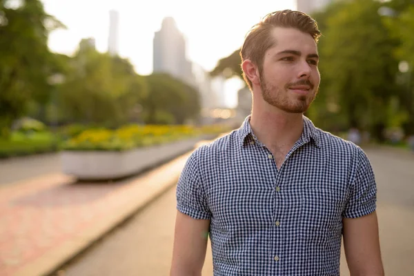 Rahatlatıcı ve parkta düşünme genç yakışıklı adam portresi
