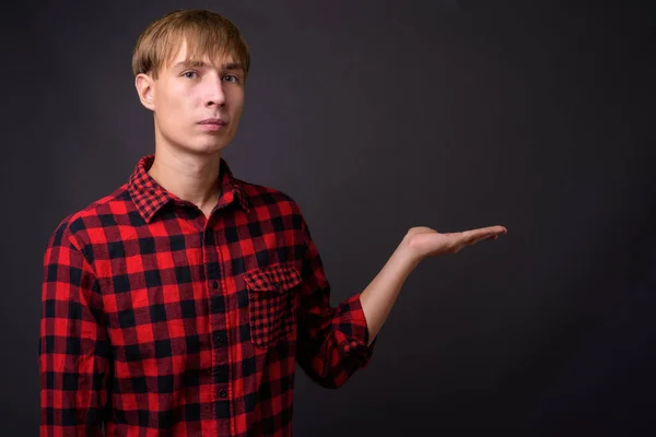 Jovem homem bonito com cabelo loiro mostrando copyspace — Fotografia de Stock