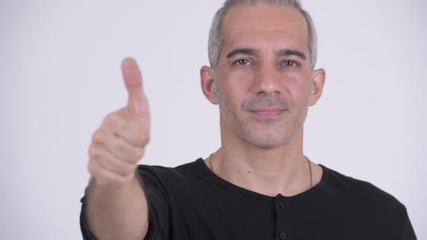 Glücklicher persischer Mann gibt vor weißem Hintergrund die Daumen hoch — Stockvideo