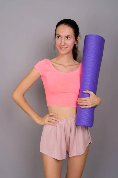 Joven hermosa mujer listo para gimnasio celebración de yoga estera —  Fotos de Stock