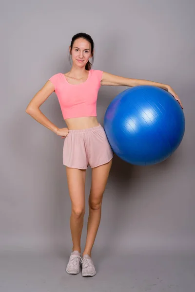Νεαρή όμορφη γυναίκα, έτοιμη για γυμναστήριο κρατώντας την μπάλα γυμναστικής — Φωτογραφία Αρχείου