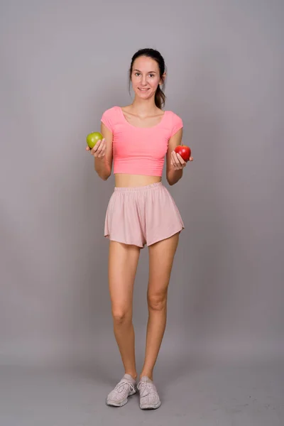 Jeune belle femme tenant pomme rouge et pomme verte — Photo