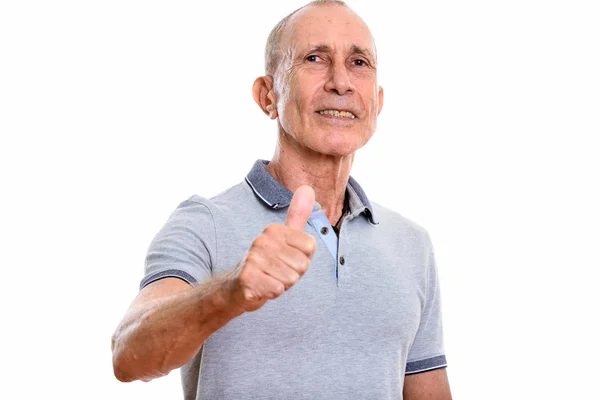Студийный снимок счастливого пожилого мужчины, улыбающегося, показывая большой палец вверх — стоковое фото