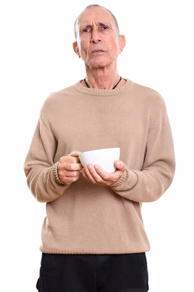 スタジオショットの怒った先輩男保持コーヒーカップ — ストック写真