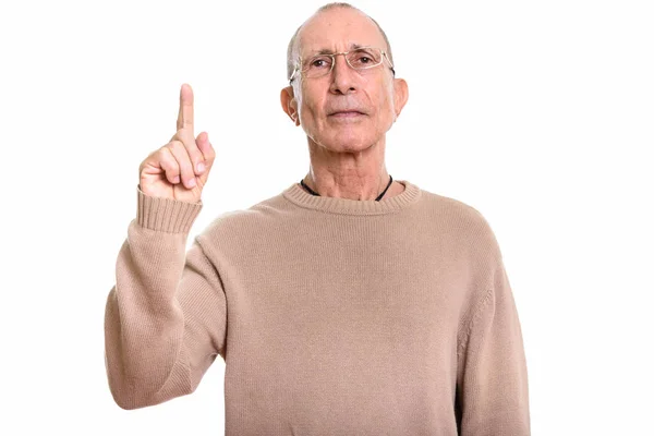 Студійний знімок старшого чоловіка в окулярах, вказуючи на — стокове фото