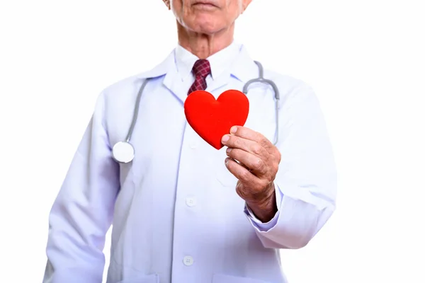 Старший врач держит красное сердце изолированы на белом фоне — стоковое фото