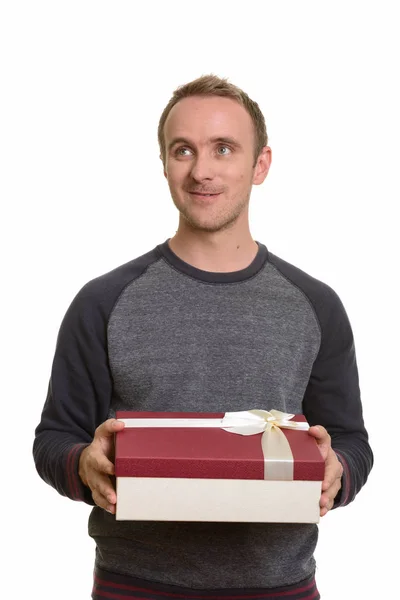 Homem caucasiano feliz segurando caixa de presente enquanto pensa pronto para Va — Fotografia de Stock