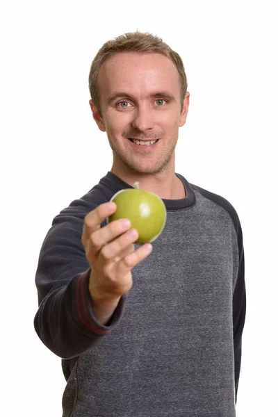 Feliz guapo caucásico hombre dando verde manzana — Foto de Stock