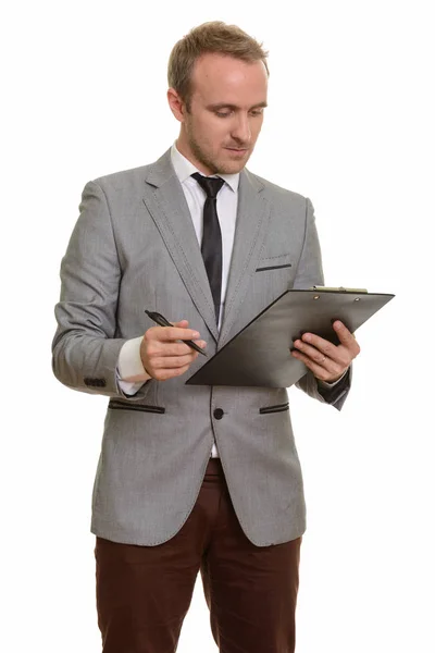 Guapo hombre de negocios caucásico escribiendo en portapapeles aislado sobre fondo blanco — Foto de Stock