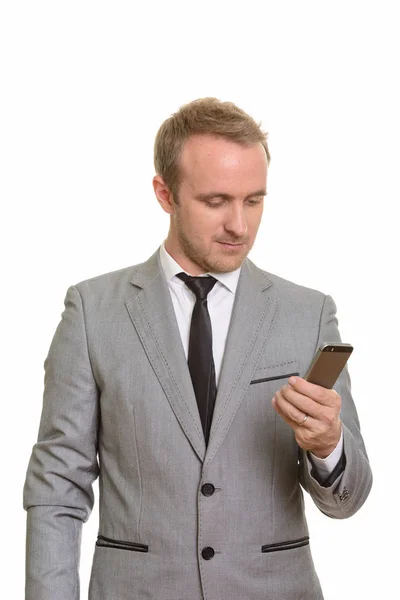 Bonito homem de negócios caucasiano segurando celular isolado contra fundo branco — Fotografia de Stock