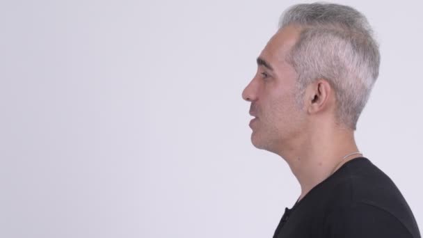 Vista de perfil del hombre persa guapo hablando sobre fondo blanco — Vídeo de stock