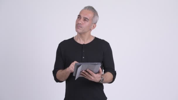 Boldog szép perzsa ember arra gondolt, digitális tábla használata közben — Stock videók