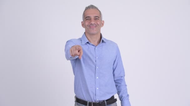 Glad persisk affärsman pekar på kameran mot vit bakgrund — Stockvideo