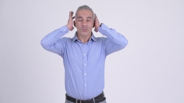 Homme d'affaires persan stressé couvrant les oreilles sur fond blanc — Video